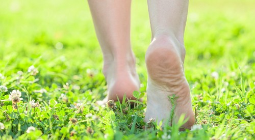 la femme marche sans chaussures sur l'herbe