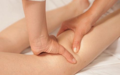 le masseur pétrit sa jambe